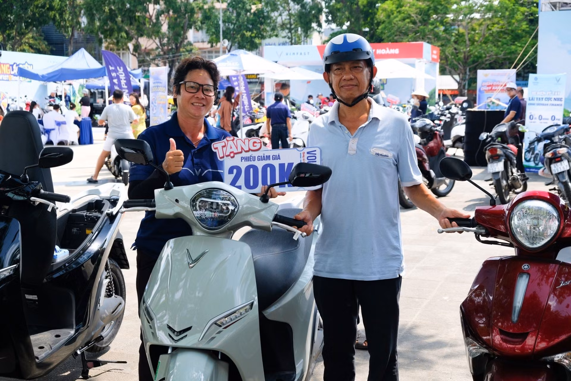 Ông Nhân đứng cạnh chiếc xe xăng cũ và mẫu VinFast Feliz 2025 vừa được đổi tại sự kiện